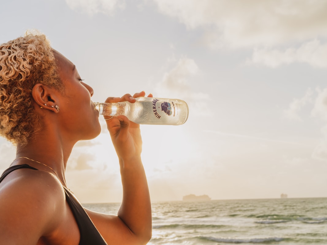 Persona hidratándose correctamente con agua fresca